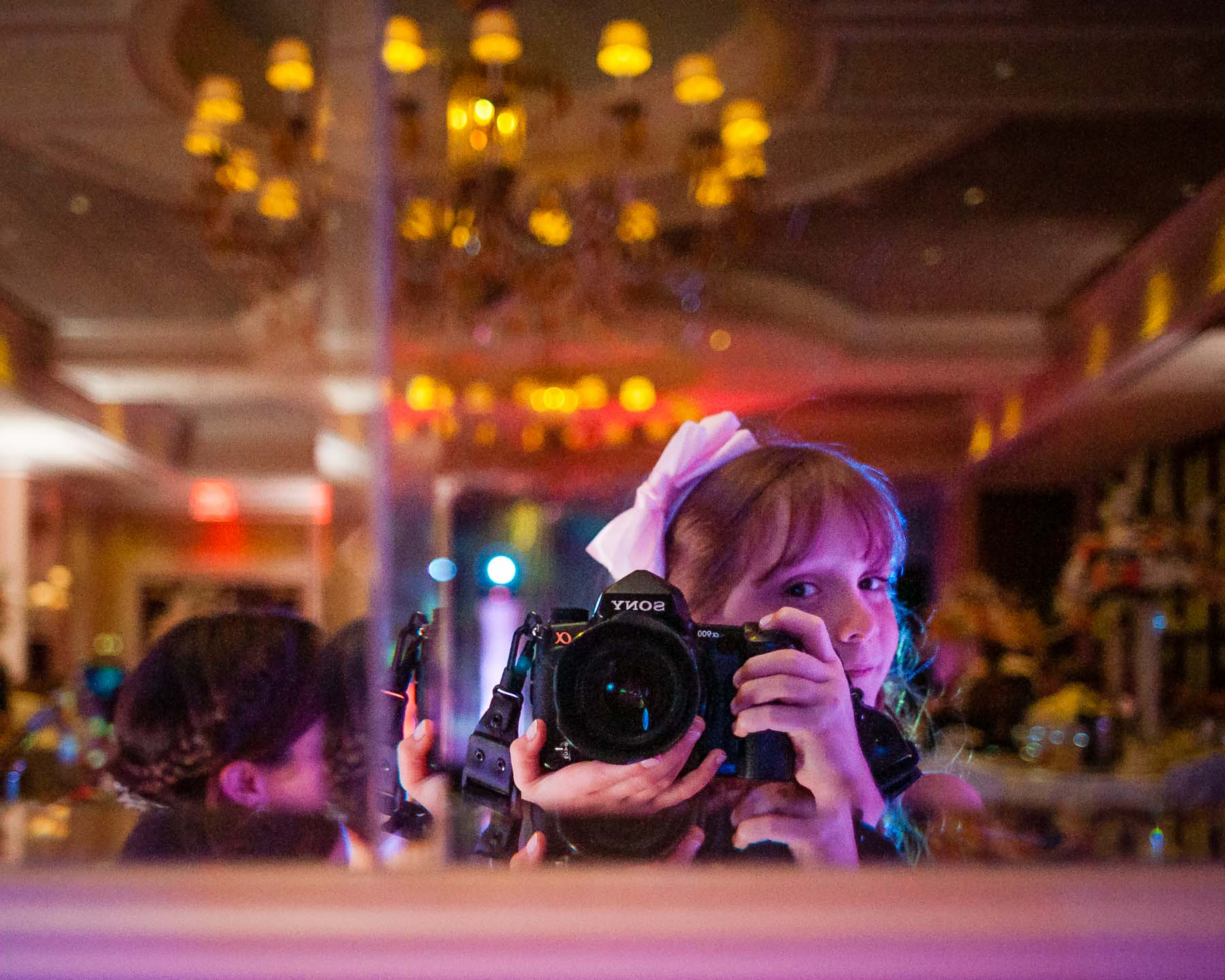 7 year old girl takes a self-portrait at a wedding with a full-frame DSLR Sony A900